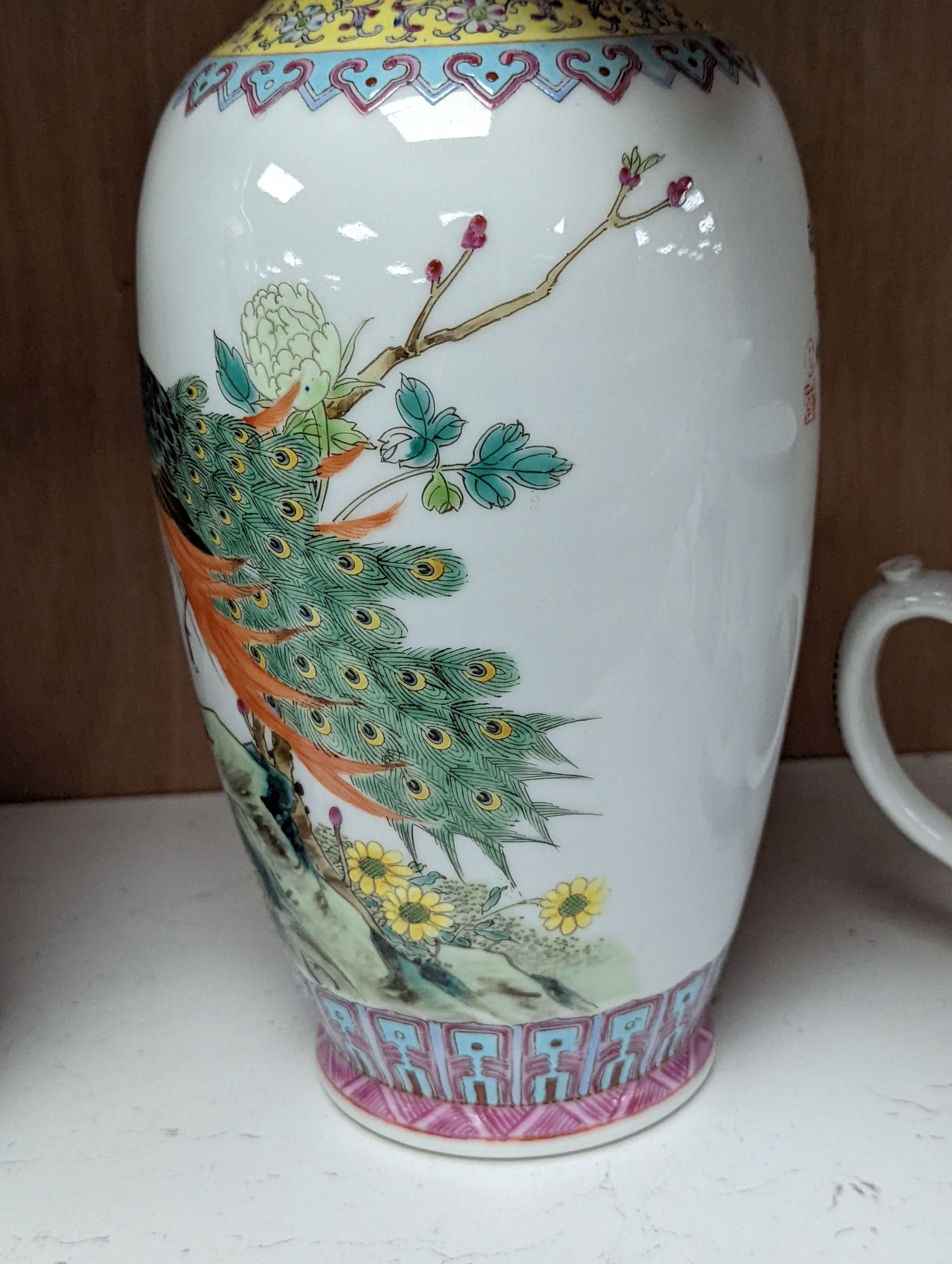 A pair of Chinese famille rose vases decorated with peacocks, 31cm